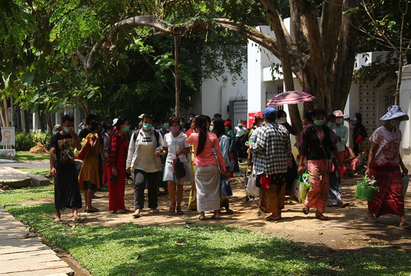 လုပ်ငန်းရှင်ထွက်ပြေးသော စက်ရုံနှစ်ရုံမှ အလုပ်သမားများ ရန်ကုန်တိုင်းအစိုးရအဖွဲ့ ရုံးရှေ့သို့ မတ် ၃၀ ရက်က လာရောက် အကူအညီ တောင်းခံခဲ့မှုကို တွေ့ရစဉ် (ဓာတ်ပုံ-ရှိုင်းလင်းအောင်)