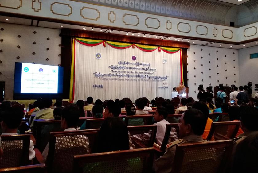 ရန်ကုန်တိုင်းဒေသကြီး အစိုးရအဖွဲ့ရုံးတွင် အပြည်ပြည်ဆိုင်ရာ သဘာဝဘေးလျော့ပါးရေးနေ့ အခမ်းအနား ပြုလုပ်နေသည်ကို တွေ့ရစဉ်