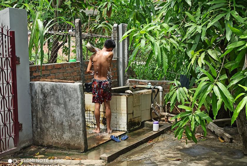 မြောက်ဒဂုံမြို့နယ်ရှိ ရပ်ကွက်တစ်ခုတွင် စက်ရေတွင်းမှရေချိုးနေစဉ်(ဓာတ်ပုံ-ဇော်ဇော်အောင်)