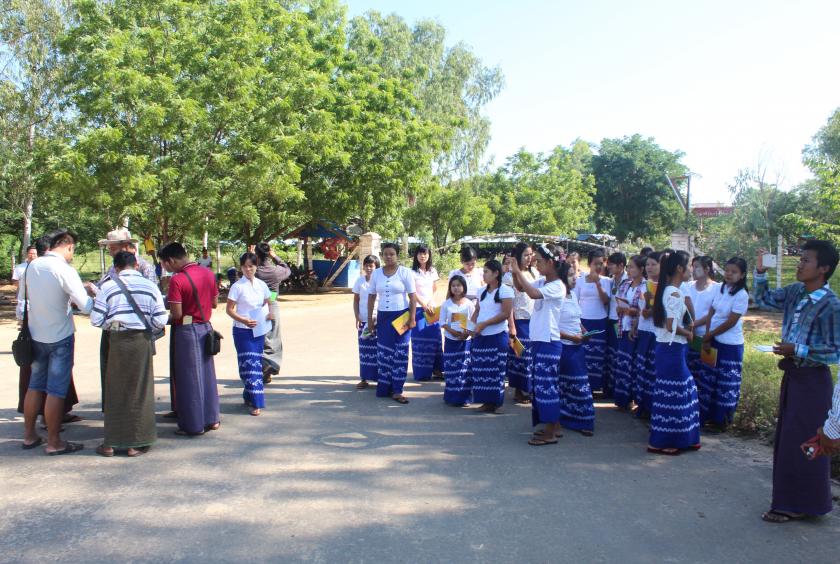 ပခုက္ကူမြို့အနီးရှိ အမှတ် (၁၁) အထည်စက်ရုံမှ အလုပ်ထုတ်ပယ်ခံထားရသည့်လုပ်သားများ စက်ရုံရှေ့တွင် စောင့်ဆိုင်းနေစဉ်