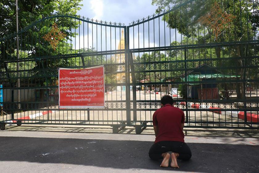 စွယ်တော်မြတ်စေတီတော်အား စေတီတော်ဝင်းအပြင်ဘက်မှ ဖူးမြော်နေသူတစ်ဦးကို တွေ့ရစဉ် (ဓာတ်ပုံ-သီဟအောင်)