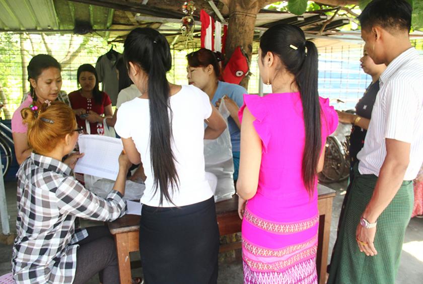 လှိုင်သာယာစက်မှုဇုန် (၂) ရှိ လက်ဝါးအထည်ချုပ်စက်ရုံ (၃) ပိတ်သိမ်းသဖြင့် အလုပ်သမားများ၏ နစ်နာကြေးပေးနေသည်ကို မေ ၁၁ ရက်က တွေ့ရစဉ် (ဓာတ်ပုံ- ရှိုင်းလင်းအောင်)