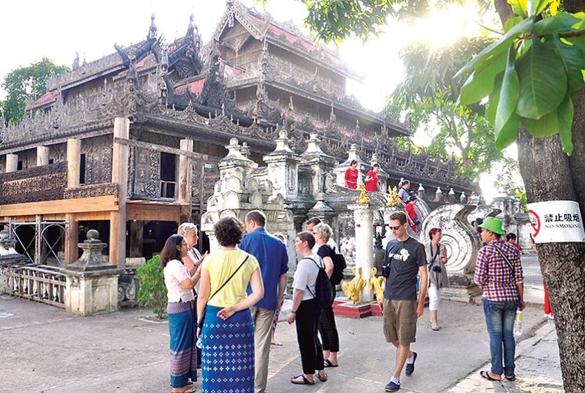   မန္တလေးမြို့ ရွှေနန်းတော်ကျောင်းသို့ လာရောက်လေ့လာနေကြသည့် နိုင်ငံခြားသားခရီးသွားများကို တွေ့ရစဉ် (ဓာတ်ပုံ-ဌေးလှအောင်)